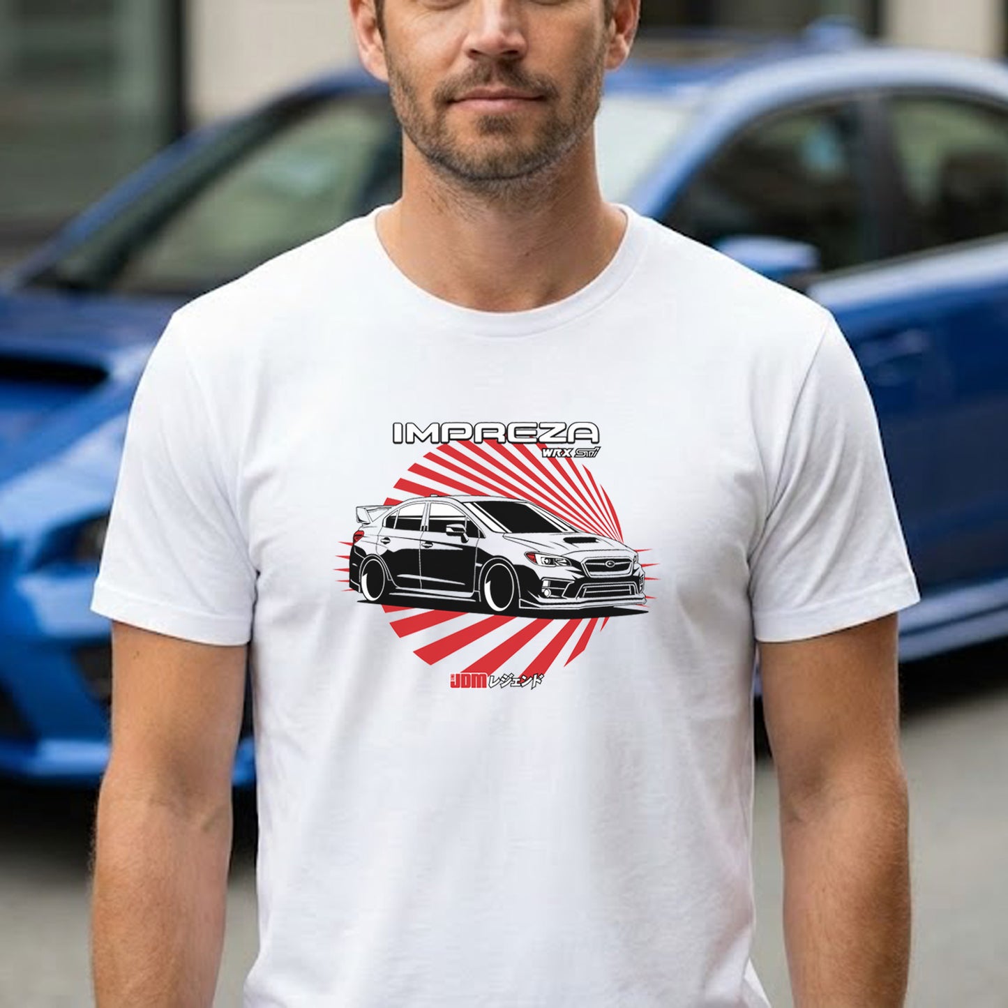Man wearing a white t-shirt with a car graphic and 'Impreza' text, standing in front of a blue car.