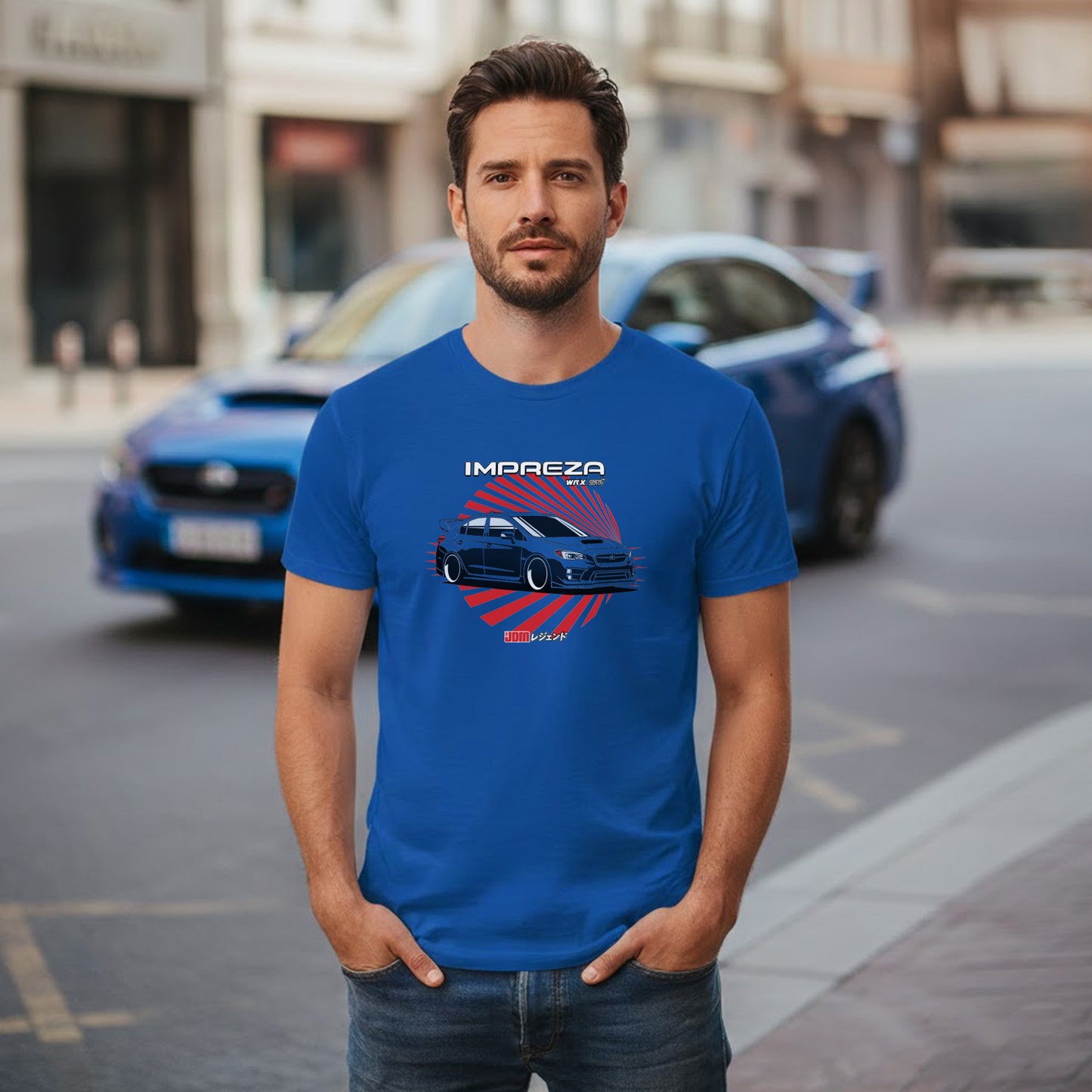 Man wearing a blue t-shirt with a car graphic and 'Impreza' text, standing on a street with a blue car in the background.