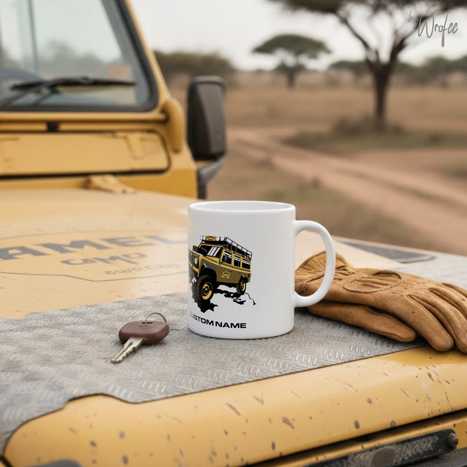 White mug with a vehicle design on a car dashboard with a glove and keys.