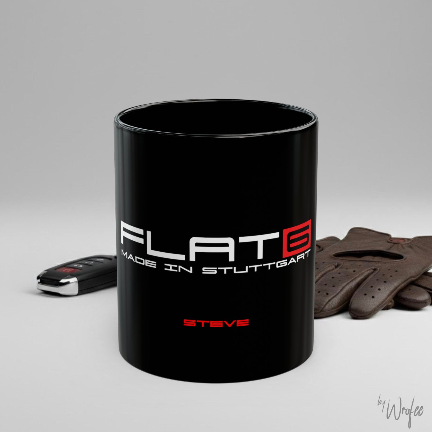 Black mug with 'FLAT6 Made in Stuttgart' branding on a gray background