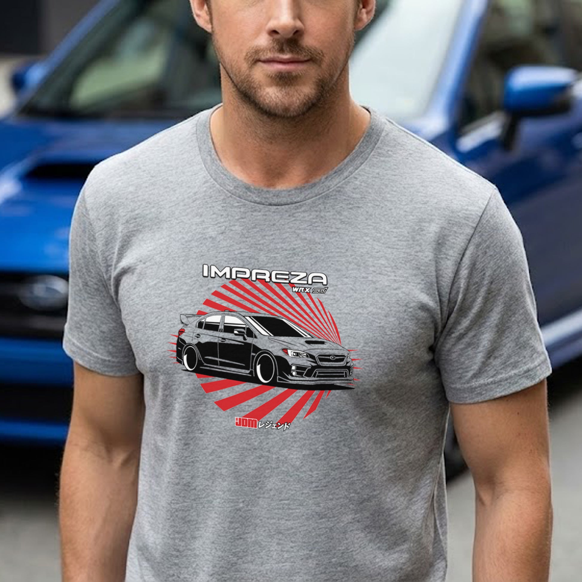 Man wearing a gray t-shirt with a car graphic and 'Impreza' text, with a blue car in the background.
